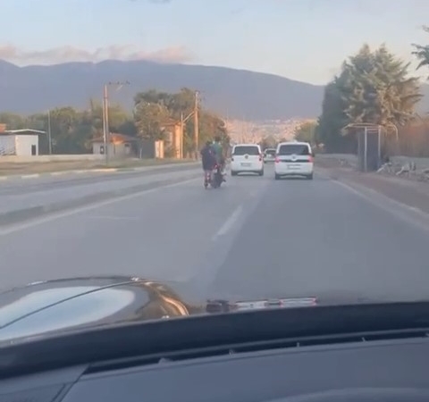 Motosiklete tutunan patenli genç ölüme meydan okudu