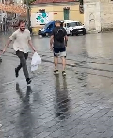 Taksim’de yağmur etkili oldu: Bir vatandaş yağmurdan kartonla korundu