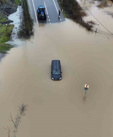 Göle dönen yolda mahsur kalan sürücü aracını bırakmadı, kurtarma anları görüntülendi