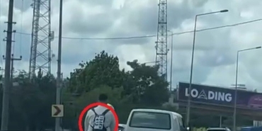 Ceza yememek için düşen plakasını sırt çantasına yapıştırdı