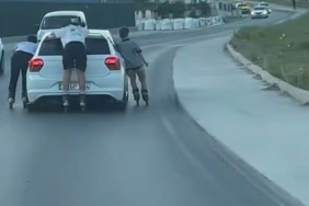 Otomobile tutunarak ilerleyen patenli çocuklar kamerada