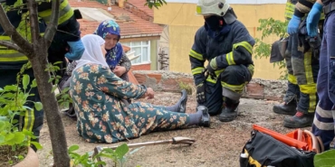 Yaşlı kadın tavukları için çıktığı çatıda mahsur kaldı