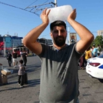 Taksim’de sıcaktan bunalan simit satıcısı buz kalıbıyla serinledi