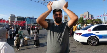 Taksim’de sıcaktan bunalan simit satıcısı buz kalıbıyla serinledi