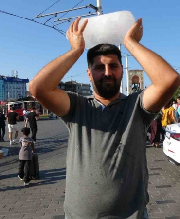 Taksim’de sıcaktan bunalan simit satıcısı buz kalıbıyla serinledi