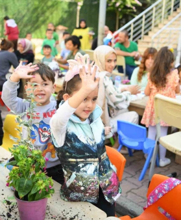 Aileler ve çocuklar birlikte saksı boyayıp çiçek ekti