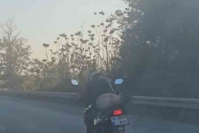 Motosikleti yatarak kullanan sürücü kamerada