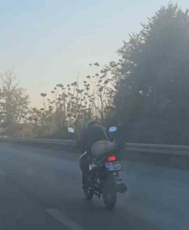 Motosikleti yatarak kullanan sürücü kamerada
