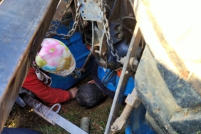 Devrilen traktörün altında kalan sürücü yaralandı