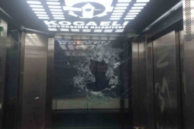 Asansörün camını kaldırım taşlarıyla parçaladı