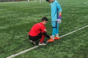 Hakem futbolcunun kramponlarını bağladı