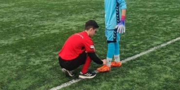 Hakem futbolcunun kramponlarını bağladı