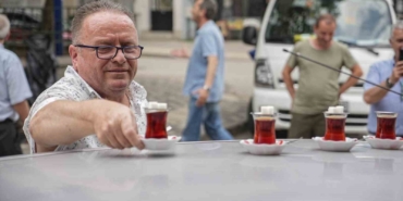 50 metre uzaklıktaki çay ocağından aldığı çayları otomobiliyle taşıyor