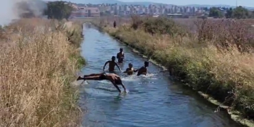 Çifte tehlike: Yangına rağmen su kanalındaki oyunlarını bozmadılar