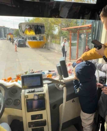 Şoför minibüse binen yolcularına meyve ve şekerleme ikram ediyor
